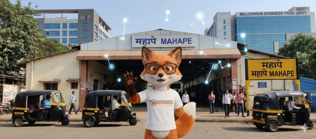 Wireframes Digital Fox Mascot with logo smiling in front of the Mahape Railway Station facade and Millennium Business Park corporate building in Navi Mumbai during daytime. A vertical local SEO asset.